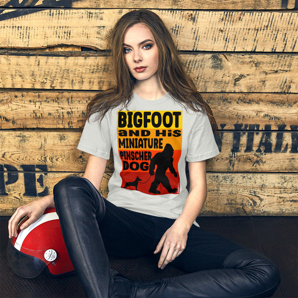 Bigfoot and his Miniature Pinscher unisex silver t-shirt by Dog Artistry.